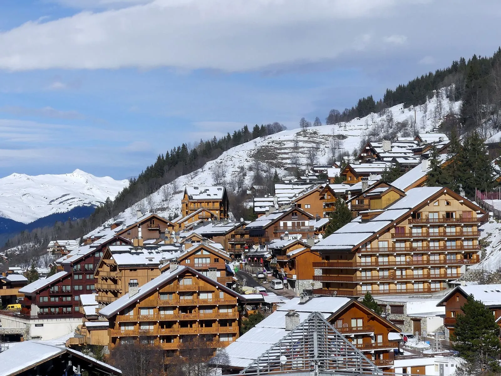 Chalets de bois et de pierre étagés sur le versant enneigé de Méribel