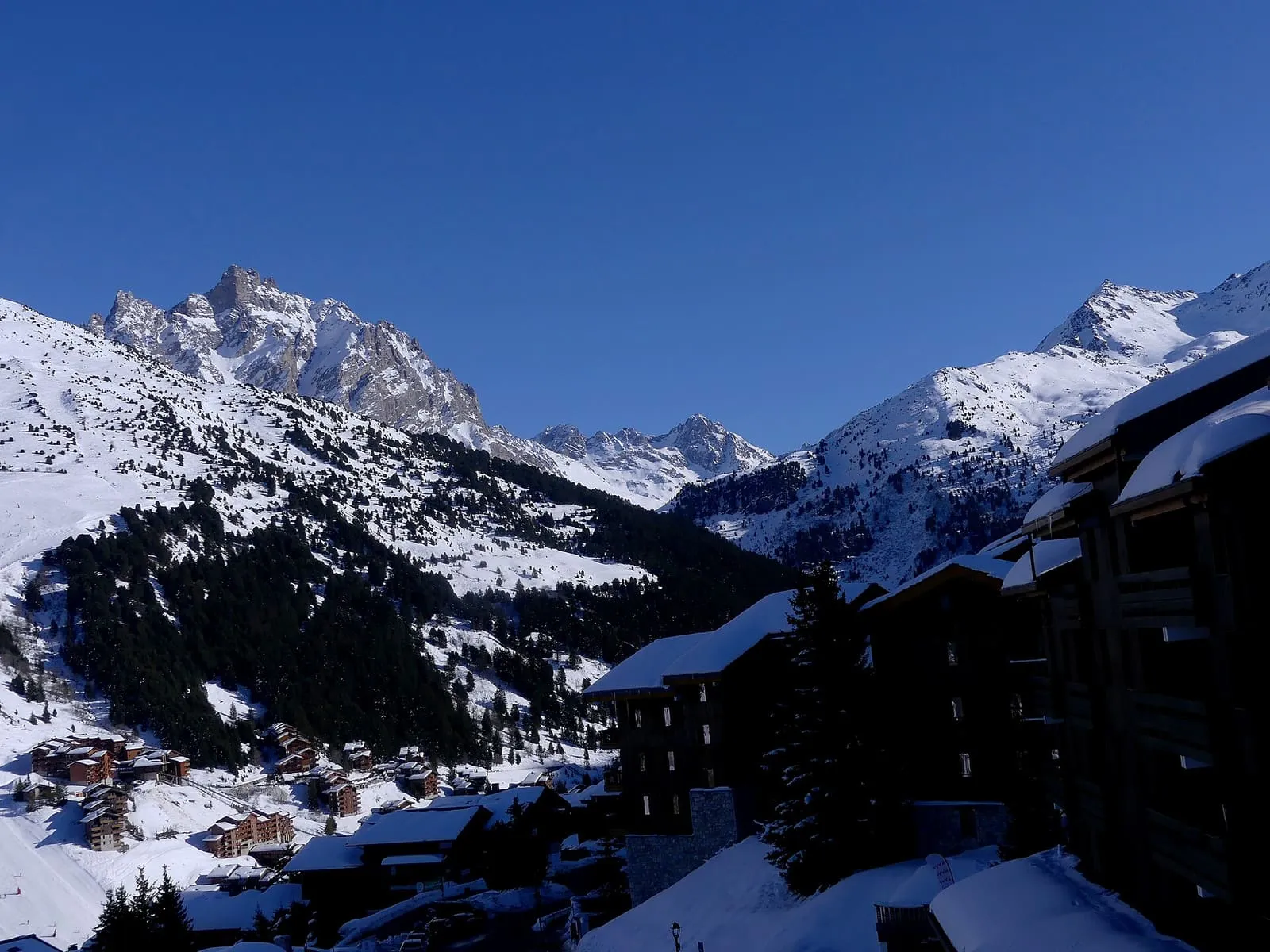 Sommets enneigés et chalets du Hameau de Mottaret en hiver